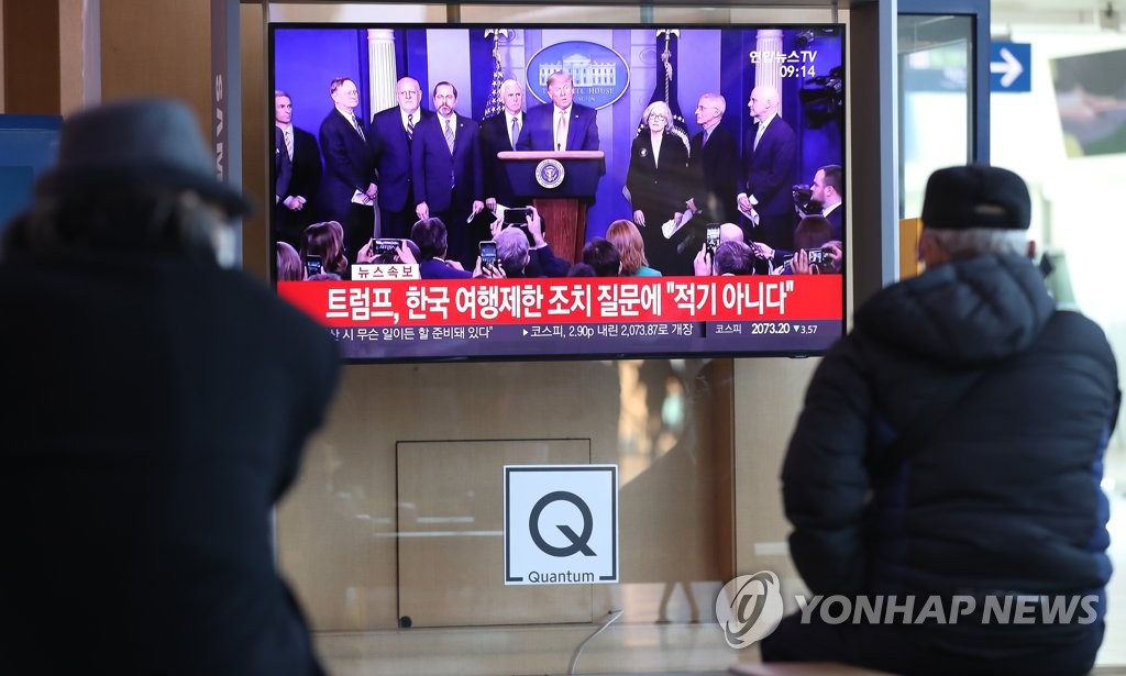 트럼프의 코로나19 회견 보도 보는 시민들
