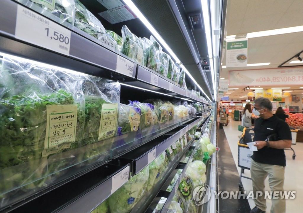 In this file photo taken on May 4, 2020, a local customer is seen looking at farmed products at a grocery store in Seoul while wearing a mask in an apparent attempt to prevent COVID-19 infection. (Yonhap)