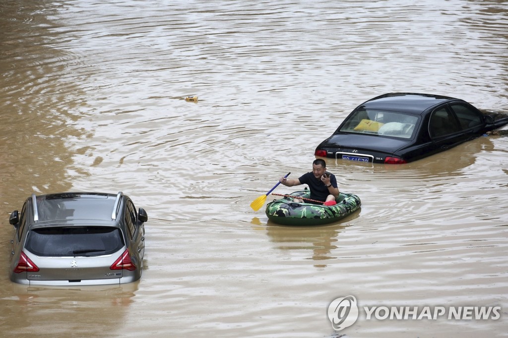 홍수 지역에서 고무보트 타고 피신하는 중국인