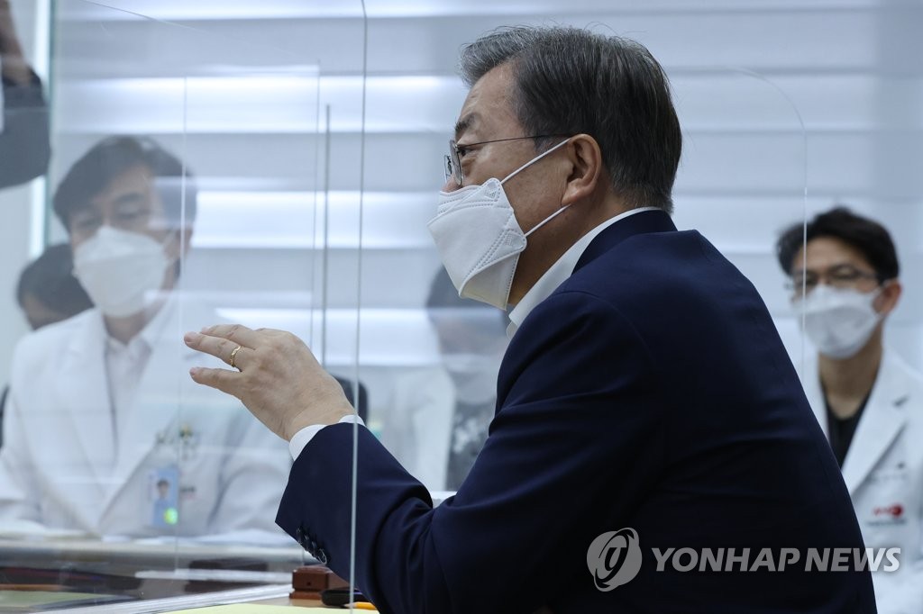 President Moon Jae-in talks with officials at the National Medical Center in Seoul during his visit there on Aug. 28, 2020. (Yonhap)