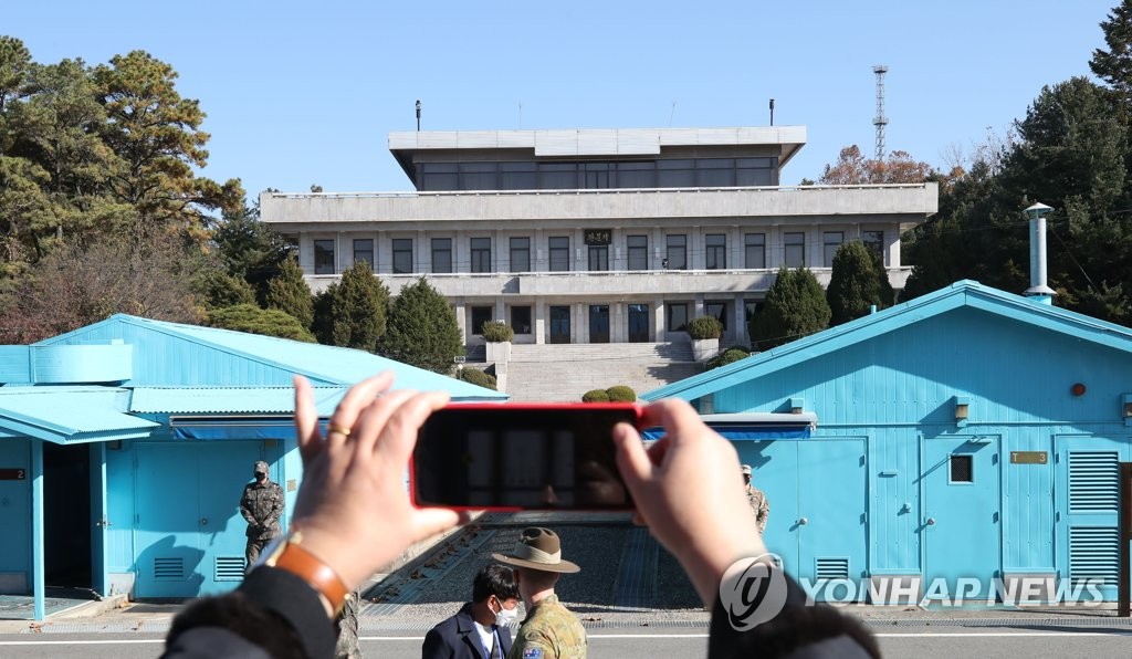 In this file photo taken by Joint Press Corps on Nov. 4, 2020, a member of a demonstration tour group takes a photo at the inter-Korean truce village of Panmunjom, north of Seoul. (PHOTO NOT FOR SALE) (Yonhap)