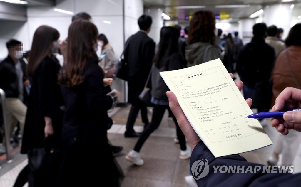 韓国で公共交通機関や医療機関などでのマスク未着用者に対する取り締まりが始まった。ソウル地下鉄５号線駅での取り締まりの様子。マスク着用義務に違反すれば過料が科される＝１３日、ソウル（聯合ニュース）
