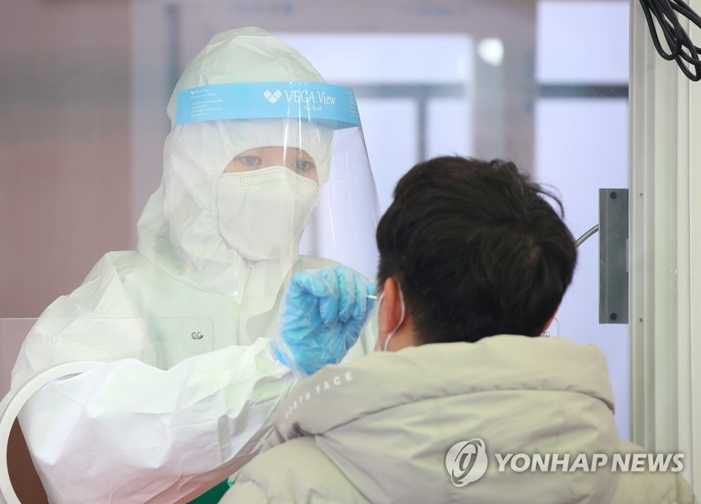 A man gets tested for COVID-19 at a screening center outside Seoul Station on March 2, 2021. (Yonhap)
