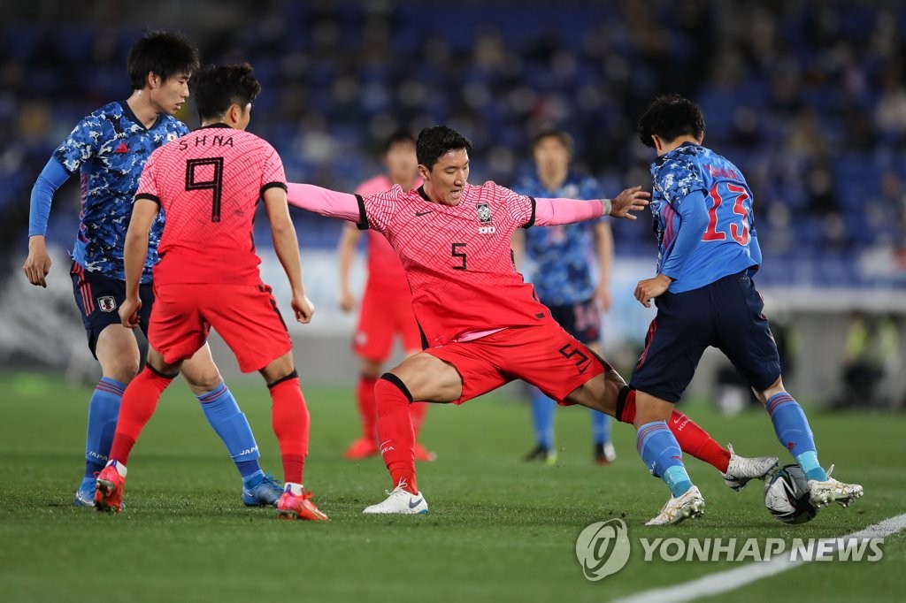 Jung Woo-young of South Korea (2nd from R) tries to steal the ball from Miki Yamane of Japan (R) during their friendly football match at Nissan Stadium in Yokohama, Japan, on March 25, 2021, in this photo provided by the Korea Football Association. (PHOTO NOT FOR SALE) (Yonhap)