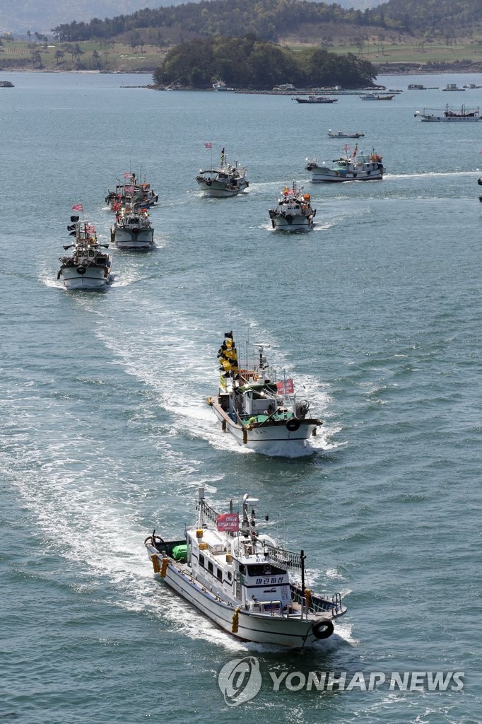 Fishing boats parade in waters off Yeosu on South Korea's south coast on April 19, 2021, to criticize Japan for its decision to discharge contaminated water from the Fukushima nuclear power plant. (Yonhap)