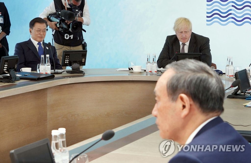 President Moon Jae-in (L), British Prime Minister Boris Johnson (C) and Japanese Prime Minister Yoshihide Suga attend a Group of Seven session in the seaside resort of Carbis Bay in Cornwall, Britain, on June 13, 2021. (Yonhap)