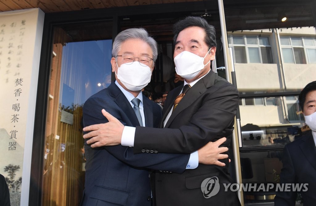 Former Democratic Party leader Lee Nak-yon (R) and Gyeonggi Gov. Lee Jae-myung hug each other during a meeting at a teahouse in the Seoul district of Jongno on Oct. 24, 2021. (Pool photo) (Yonhap)