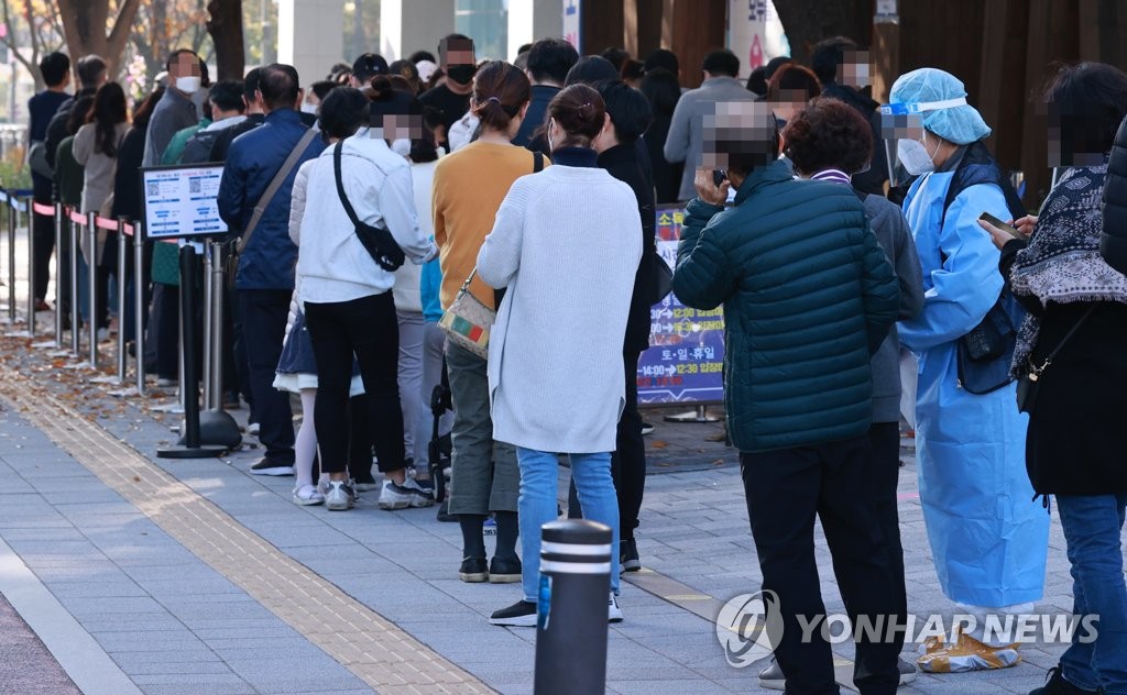 People stand in line to take coronavirus tests at a COVID-19 test center in Seoul on Nov. 7, 2021. (Yonhap)