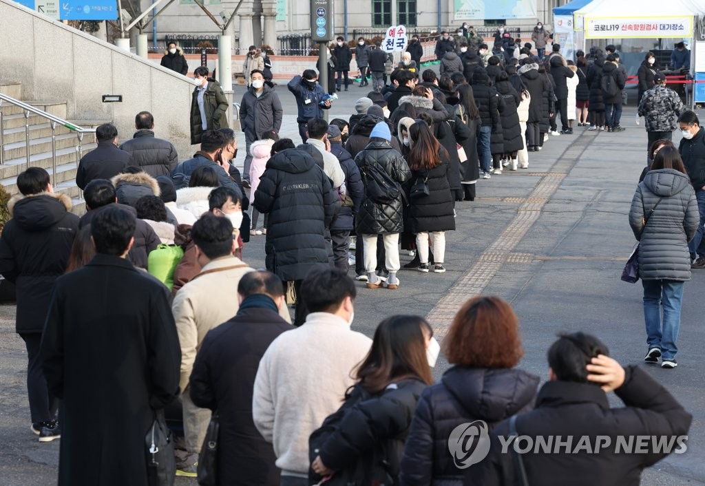ソウル駅前の広場に設置されている新型コロナの臨時検査所に大勢の市民が並んでいる＝８日、ソウル（聯合ニュース）