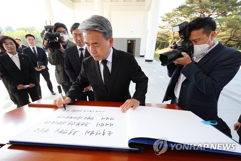 Defense Minister Lee Jong-sup writes a message on the visitors' book during a visit to the Seoul National Cemetery in central Seoul on May 11, 2022. (Yonhap)