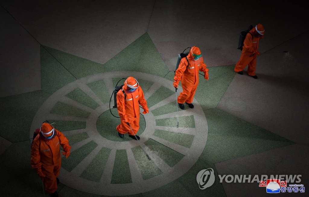 In this photo from the North's Korean Central News Agency on May 17, 2022, health care workers disinfect an area in Pyongyang Station in the capital amid an outbreak of COVID-19. (For Use Only in the Republic of Korea. No Redistribution) (Yonhap)