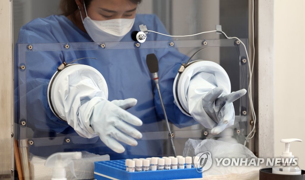 A medical worker prepares to conduct COVID-19 tests at a testing station in Seoul's western district of Seodaemun on May 19, 2022. (Yonhap)