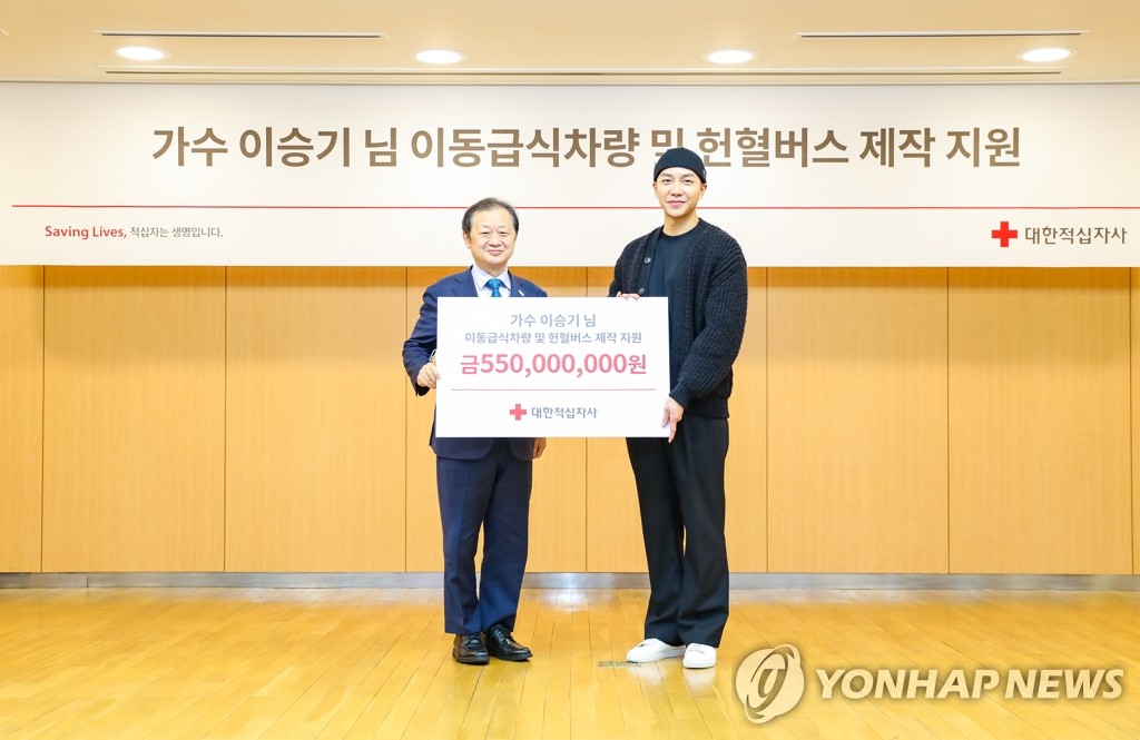 Le chanteur Lee Seung-gi (à dr.) et Shin Hee-young, chef de la Croix-Rouge sud-coréenne, posent pour une photo lors de la cérémonie tenue à l'occasion du don de Lee de 550 millions de wons, au bureau de l'organisation à Séoul le 13 janvier 2023. (Photo fournie par l'organisation humanitaire. Revente et archivage interdits)