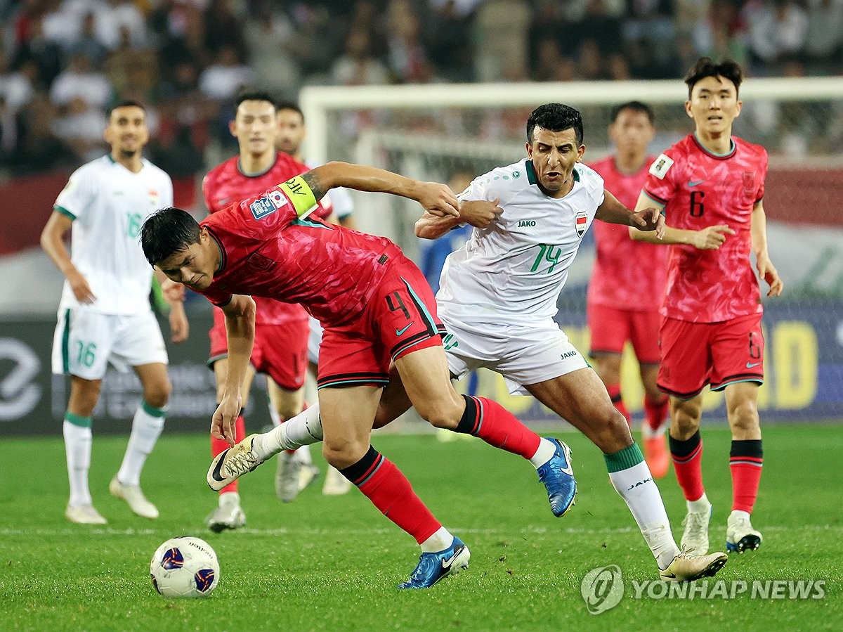 Kim Min-jae of South Korea (L) battles Amjad Attwan of Iraq for the ball during the teams' Group B match in the third round of the Asian World Cup qualification at Yongin Mireu Stadium in Yongin, Gyeonggi Province, on Oct. 15, 2024. (Yonhap)