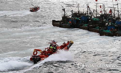 In this photo provided by the Korea Coast Guard, a Korean speedboat moves in on Chinese fishing boats in South Korea's territorial waters in the West Sea on Dec. 27, 2012. (Yonhap) 