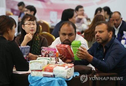 Overseas buyers compare cosmetic products during a business consultation session on Oct. 16, 2015. (Yonhap) 