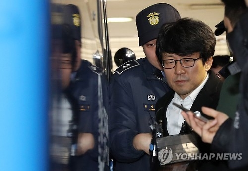 This photo, taken on Dec. 31, 2016, shows Ryu Chul-kyun, a professor of Ewha Womans University, being escorted by police in Seoul to face questioning by the independent counsel team investigating a corruption scandal involving President Park Geun-hye and her friend. (Yonhap)