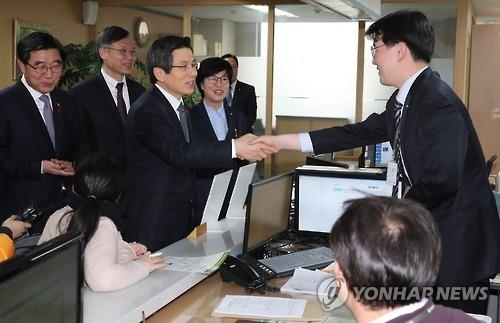 Acting President and Prime Minister Hwang Kyo-ahn shakes hands with a worker (R) during his visit to an office of the state-run Korea Workers' Compensation and Welfare Service in central Seoul on Jan. 17, 2017. (Yonhap) 