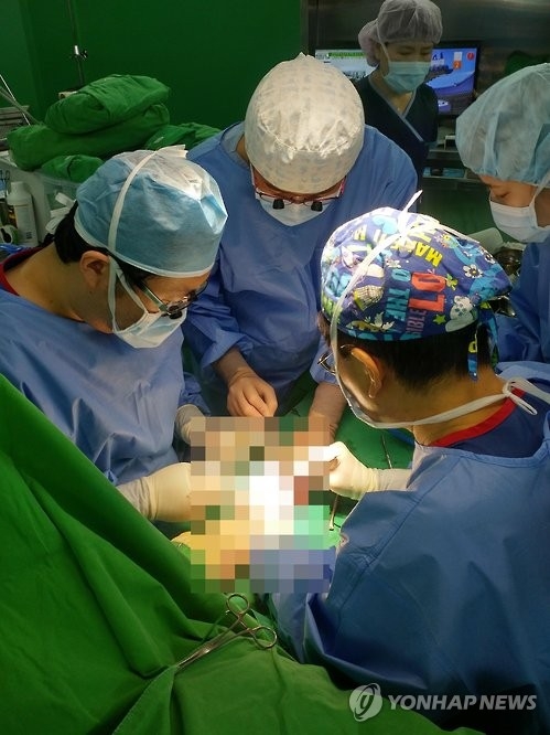 A team of doctors performs a hand transplant on a man in his 30s at Yeungnam University Medical Center in the southeastern city of Daegu on Feb. 2, 2017. (Yonhap)