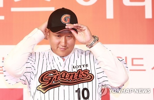 In this file photo taken on Jan. 30, 2017, Lee Dae-ho of the Lotte Giants puts on his team's cap during a press conference in Seoul. (Yonhap)