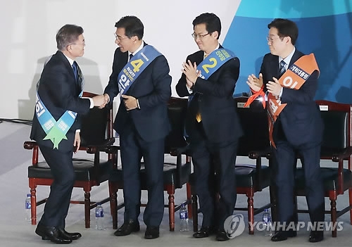 Moon Jae-in (L), presidential candidate of the liberal Democratic Party, shakes hands with his rivals in the party primary after winning the party's nomination for the upcoming presidential election in the final round of a primary held in Seoul on April 3, 2017. (Yonhap)