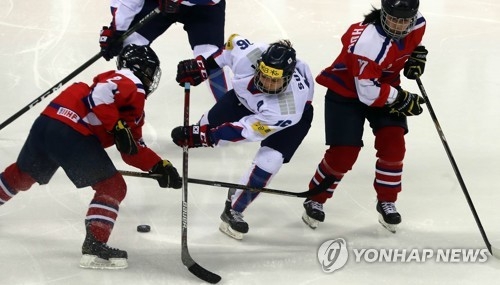 South Korean forward Jo Su-sie tries to handle the puck between two North Korean players at the International Ice Hockey Federation Women's World Championship Division II Group A at Gangneung Hockey Centre in Gangneung, Gangwon Province, on April 6, 2017. (Yonhap)