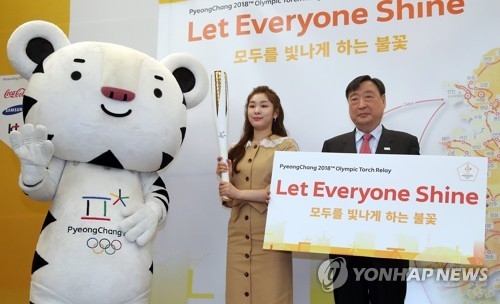 Kim Yu-na, former Olympic figure skating champion and honorary ambassador for the 2018 PyeongChang Winter Olympics, poses with the Olympic torch, flanked by Soohorang (L), the PyeongChang 2018 mascot, and Lee Hee-beom, head of PyeongChang's organizing committee, in Seoul on April 18, 2017. (Yonhap)