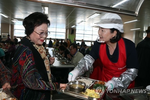 Kim Jung-sook (R), the wife of presidential candidate Moon Jae-in, serves food to the elderly in Gwangju on April 14, 2017. (Yonhap)