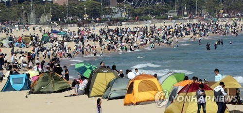 In this photo taken on May 3, 2017, beachgoers crowd Haeundae Beach in the southeastern port city of Busan with some pitching tents to avoid the heat. (Yonhap) 