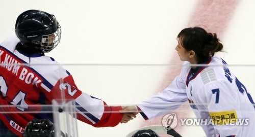 In this file photo, taken on April 7, 2017, South Korean women's hockey captain Lee Kyou-sun (R) shakes hands with her North Korean counterpart Kim Kum-bok before their game at the International Ice Hockey Federation Women's World Championship Division II Group A tournament at Gangneung Ice Arena in Gangneung, Gangwon Province. (Yonhap)