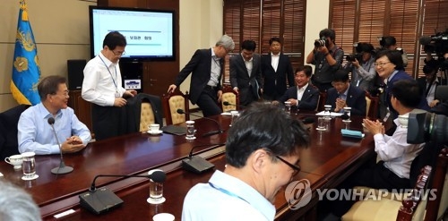 President Moon Jae-in (L) speaks with his top presidential secretaries before the start of their weekly meeting at the presidential office Cheong Wa Dae on June 22, 2017. (Yonhap)