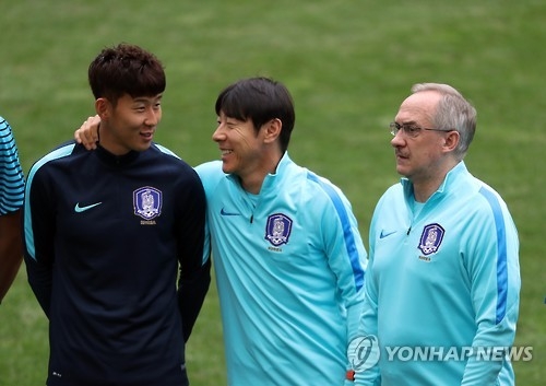 In this file photo taken on Aug. 29, 2016, Shin Tae-yong (2nd from L), then assistant coach to South Korea football head coach Uli Stielike (R), talks with Son Heung-min before training at Seoul World Cup Stadium in Seoul. (Yonhap)