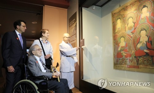 American Robert Mattielli (2nd from L), his wife Sandra (3rd from L) and Portland Art Museum Director and Chief Curator Brian Ferriso (far L) view the painting "Obuldo," a depiction of Five Buddhas, at Songgwang Temple in Suncheon, 415 kilometers southwest of Seoul. (Yonhap) 