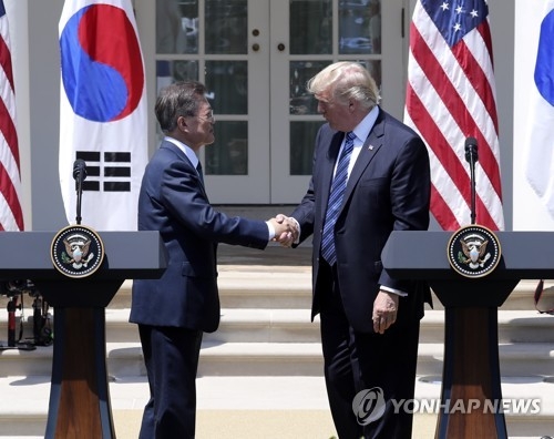 South Korean President Moon Jae-in (L) and U.S. President Donald Trump shake hands after a joint press conference that followed their bilateral summit at the White House on June 30, 2017. (Yonhap)