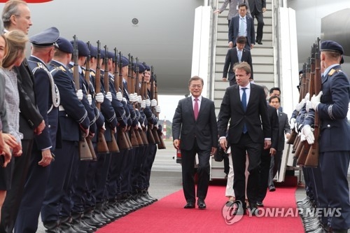 South Korean President Moon Jae-in (wearing a pink tie) walks out of his Air Force One after arriving in Berlin on July 5, 2017, on an official visit that will include a bilateral summit with German Chancellor Angela Merkel. (Yonhap)