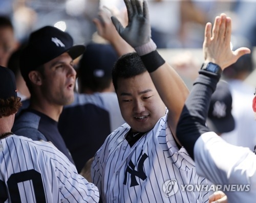 In this photo taken by the Associated Press, New York Yankees' South Korean player Choi Ji-man (C) celebrates with teammates after hitting a two-run home run against the Toronto Blue Jays at Yankee Stadium in New York on July 5, 2017. (Yonhap)