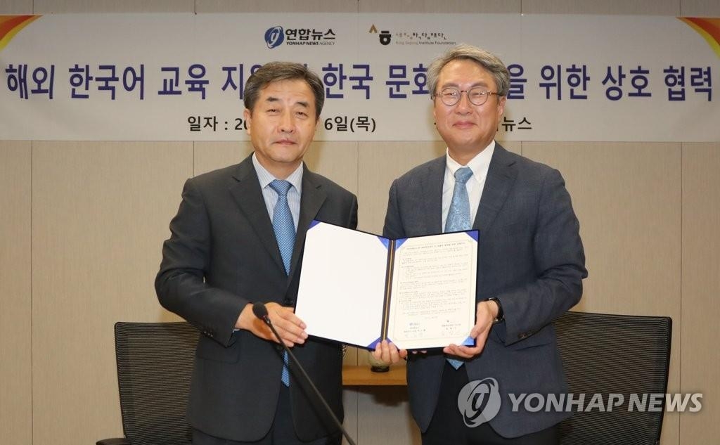 Park No-hwang, president and CEO of Yonhap News Agency, and Song Hyang-keun, president of the King Sejong Institute Foundation, pose for a photo after signing a memorandum of understanding on July 6, 2017, at the news agency's Seoul headquarters. (Yonhap)