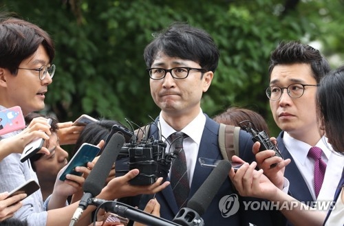 Lee Jun-seo, a former senior member of the minor opposition People's Party who's suspected of taking part in a fake tip-off scandal, answers questions from reporters with a stiff expression before entering the courthouse for a hearing on his arrest warrant in Seoul on July 11, 2017. (Yonhap) 
