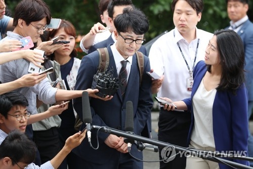 Lee Jun-seo, a former senior member of the minor opposition People's Party suspected of taking part in a fake tip-off scandal, is surrounded by reporters asking questions as he enters the courthouse for a hearing on his arrest warrant in Seoul on July 11, 2017. (Yonhap)