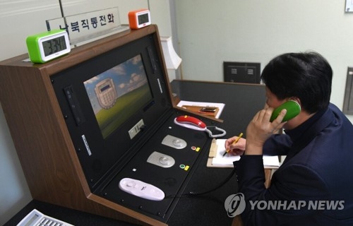 This photo, provided by South Korea's unification ministry on Jan. 3, 2018, shows a liaison official talking with his North Korean counterpart via the reopened inter-Korean hotline at the truce village of Panmunjom. (Yonhap)