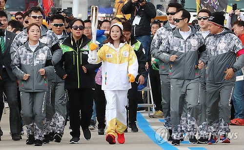 In this file photo taken on Nov. 1, 2017, South Korean figure skater You Young (C) carries the torch for the 2018 PyeongChang Winter Olympics on Incheon Bridge in Incheon. You was the first torchbearer for PyeongChang 2018. (Yonhap)
