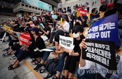 Protesters from Asiana Airlines and Korean Air, wearing hats, sunglasses and masks to protect their identities, stage a rally in central Gwanghwamun on July 8, 2018, denouncing their top management for recent troubles that have stirred up huge public outrage. (Yonhap) 