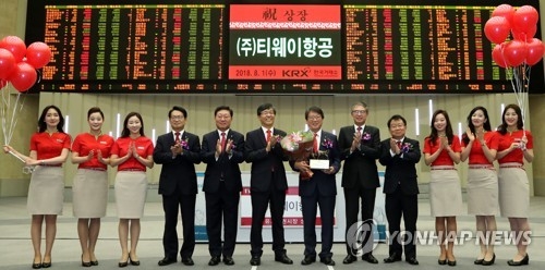 Representatives from T'way Air Co. and the Korea Exchange pose for a photo to celebrate the debut of the budget airline on South Korea's main stock market on Aug. 1, 2018. (Yonhap)