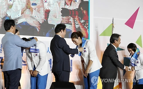 South Korean basketball player Lim Yung-hui (third from R) receives a towel from Prime Minister Lee Nak-yon during the South Korean delegation's launch ceremony for the 2018 Asian Games at SK Olympic Handball Gymnasium in Seoul on Aug. 7, 2018. Lim is the captain of the joint Korean women's team at the Aug. 18-Sept. 2 Asian Games in Jakarta and Palembang, Indonesia. (Yonhap)