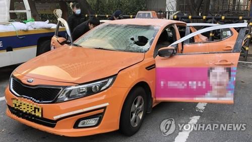 Police investigators examine a taxi in which a driver set himself on fire in front of the National Assembly in Seoul on Dec. 10, 2018. (Yonhap)