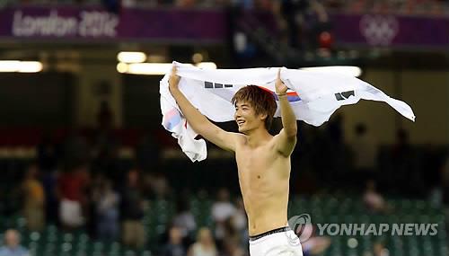 This file photo, taken on Aug. 10, 2012, shows South Korea's Ki Sung-yueng celebrating with the national flag after winning a bronze medal in the men's football competition at the 2012 London Olympic Games. (Yonhap)
