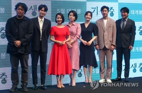 Bong Joon-ho (L), the director of film "Parasite," and its cast members pose for photos during a press conference for the film at a Seoul hotel on April 22, 2019. (Yonhap)