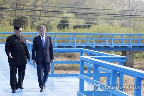 South Korean President Moon Jae-in (R) and North Korean leader Kim Jong-un have a conversation on the Footbridge during their summit meeting at the truce village of Panmunjom on April 27, 2018, in this file photo. (Yonhap)