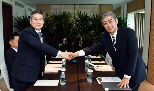 South Korean Defense Minister Jeong Kyeong-doo (L) shakes hands with Japanese Defense Minister Takeshi Iwaya in Singapore on June 1, 2019. (Yonhap) 