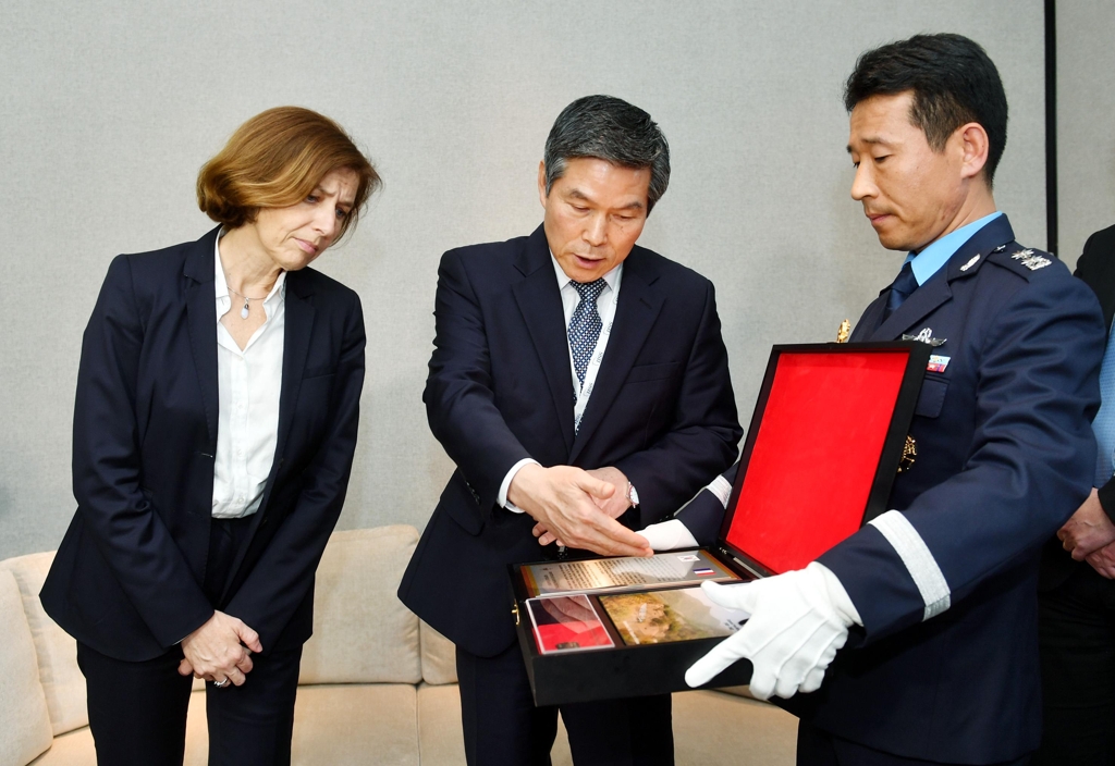 South Korean Defense Minister Jeong Kyeong-doo (C) talks about the dog tag of a French medic who died during the Korean War to his French counterpart, Florence Parly (L), during their bilateral talks in Singapore on June 1, 2019. (Yonhap)